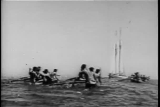 Widok z tyłu tubylców w kajak Wiosłowanie w kierunku łodzi na morzu — Wideo stockowe