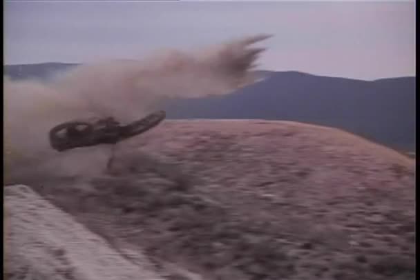 Motocicleta voando fora da estrada seguido por motociclista — Vídeo de Stock