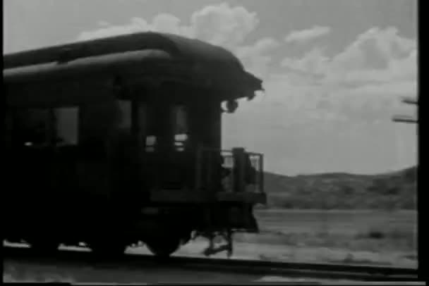 Wide shot cowboy on horseback chasing train — Stock Video