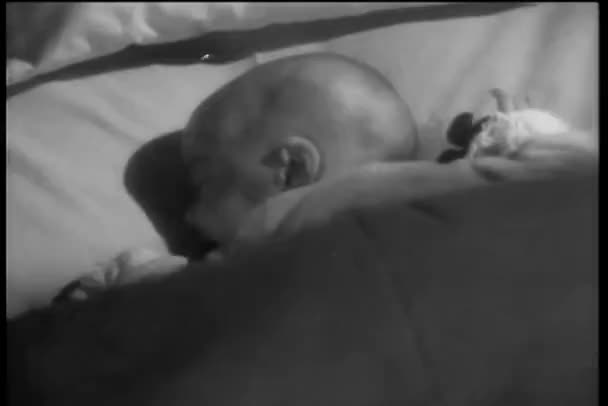 Vue arrière du bébé tournant la tête dans le lit — Video