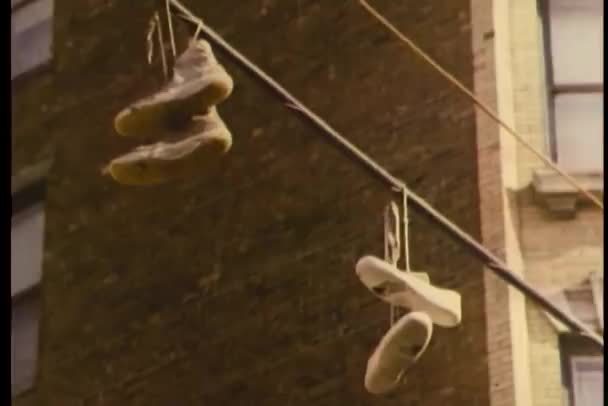 Sneakers hanging from pole in street — Stock Video