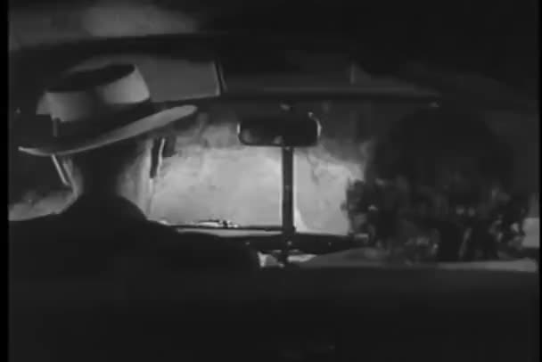 Мужчина и женщина в машине едут под дождем — стоковое видео