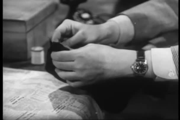 Man darning sock at table — Stock Video