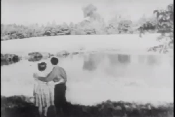 Casal assistindo fogo florestal do outro lado da lagoa — Vídeo de Stock