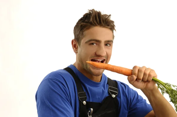 Joven trabajador comiendo zanahoria —  Fotos de Stock