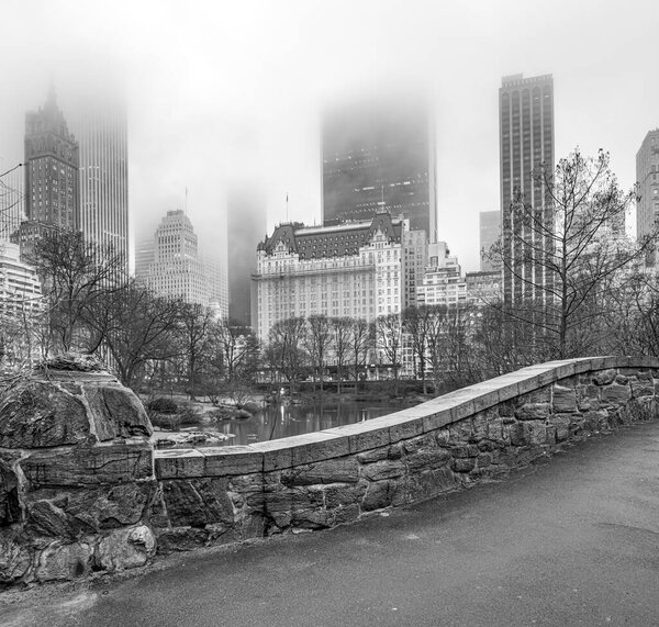 Gapstow Bridge in Central Park in early spring, with dense fog in morning