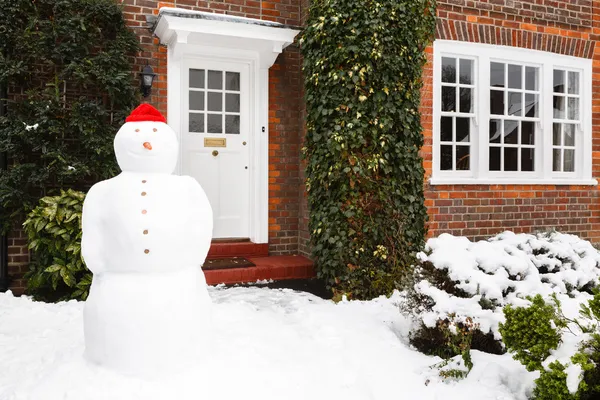 Snowman outside house — Stock Photo, Image