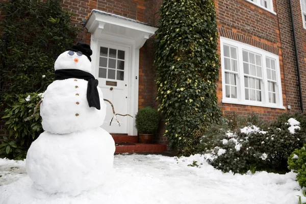 Снеговик и дом — стоковое фото
