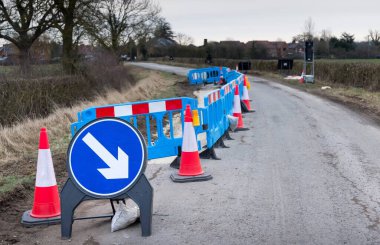 Buckinghamshire, İngiltere 'de bir köy yolunda trafik konileri ve uyarı levhalarıyla yol çalışması