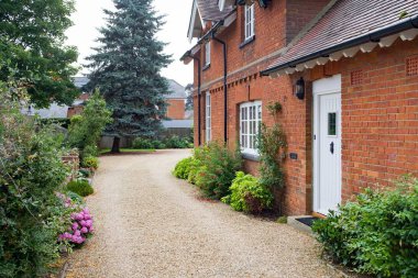 Garden and gravel driveway outside UK country house in summer. Victorian English house or mansion clipart