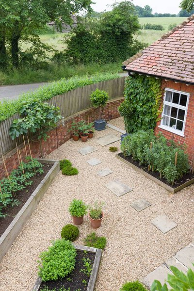 Landscaped garden with gravel, raised beds and York stone stepping stones and patio. UK garden design