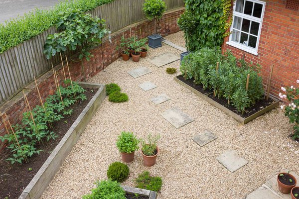 Landscaped garden UK. Hard landscaping with gravel, York stone stepping stones and oak sleeper raised beds