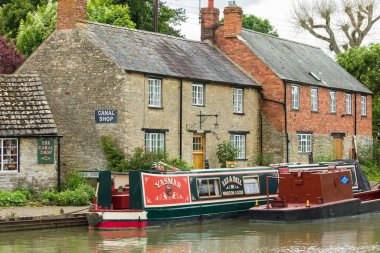 NORTHAMPTONSHIRE, İngiltere - 25 Mayıs 2022. Büyük Birlik Kanalı 'nda tarihi bir köy olan Stoke Bruerne' deki dar kayıklar ve kanal mağazası.