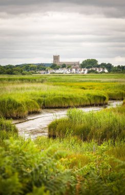 Hengistbury Head nature reserve wetlands with Christchurch Harbour and Priory in the background. Dorset, UK
