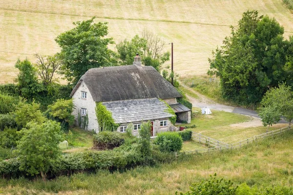 Aerial view of old thatched cottage in rural Dorset countryside