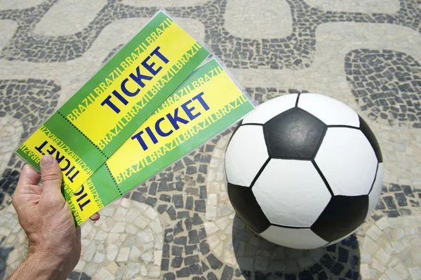 Soccer fan holds tickets above football in Brazil