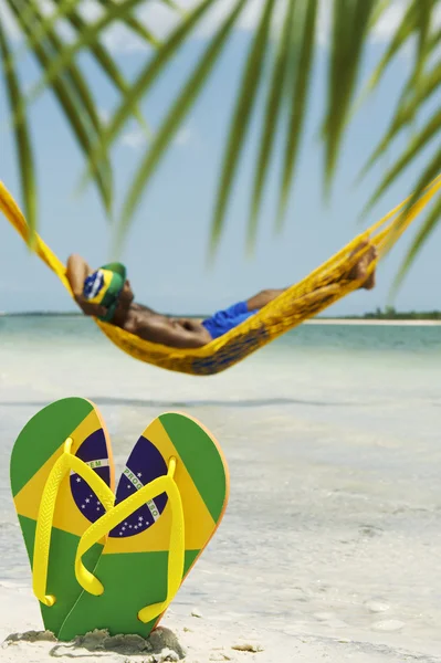 Mann slapper av i Hammock på brasiliansk strand – stockfoto