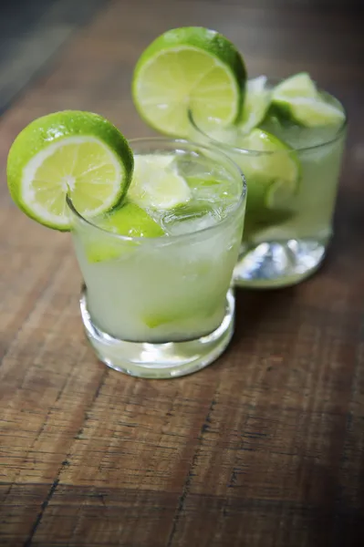 Två färsk lime caipirinhas wood tabell — Stockfoto