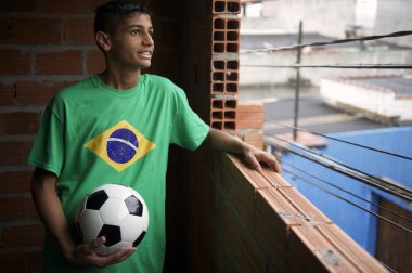 Brezilyalı genç gülümseyen futbol futbol topuyla durur