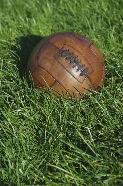 Vintage brązowy piłki nożnej Piłka nożna piłka zielone boisko — Zdjęcie stockowe
