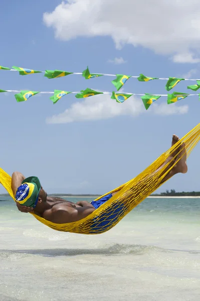 Han slapper av i Hammock på Brasiliansk strand – stockfoto