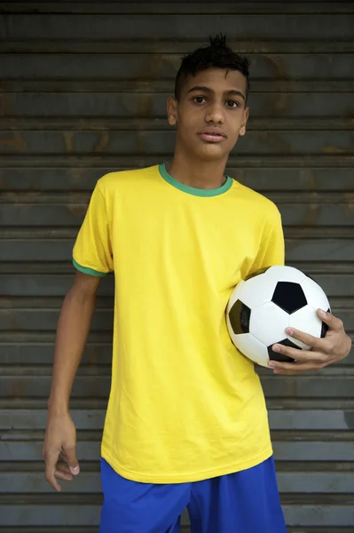 Молодой бразильский футболист проводит футбольный мяч — стоковое фото