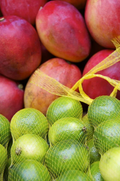 Friss piros mangó fényes zöld limes brazil trópusi mezőgazdasági termelők piacra — Stock Fotó