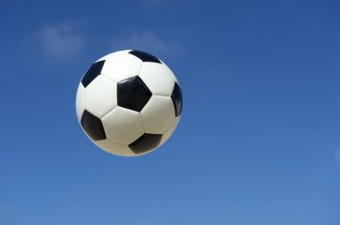 mavi gökyüzünde uçan klasik siyah-beyaz futbol topu futbol