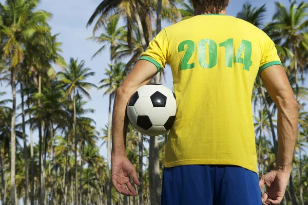 Brazilský fotbalový hráč drží fotbalový míč palmy — Stock fotografie