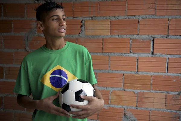 Портрет молодого бразильского футболиста, стоящего с футболом — стоковое фото