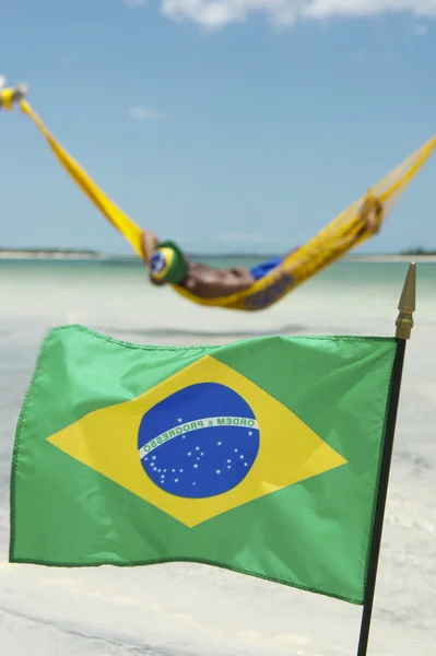 Бразильский флаг машет перед пляжными гамаками — стоковое фото