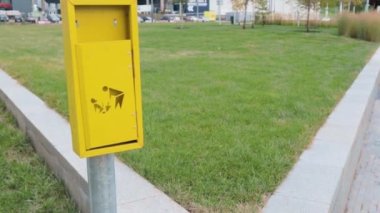 Çimenlik parkında evcil köpek atığı tabelası olan konteynır. Şehir hayatı.