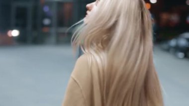 beautiful young girl blonde walks around the night city. slow motion .neon lights