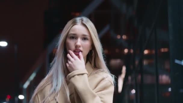 Schöne junge Blondine spaziert durch die nächtliche Stadt — Stockvideo