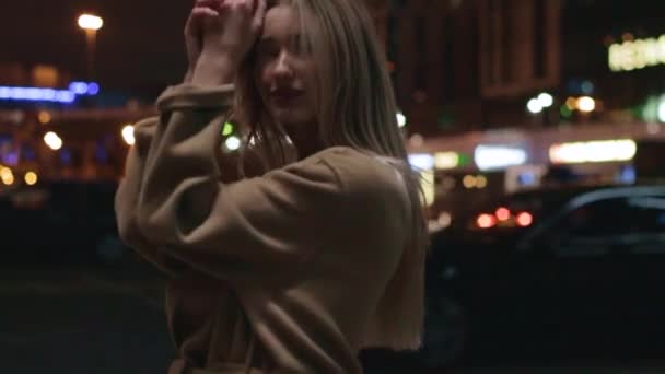 Beautiful young girl blonde walks around the night city – stockvideo