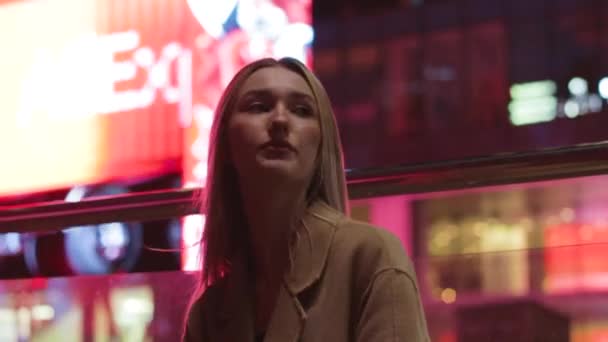 Hermosa chica joven rubia pasea por la ciudad de noche — Vídeos de Stock