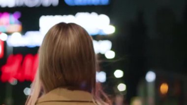 beautiful young girl blonde walks around the night city