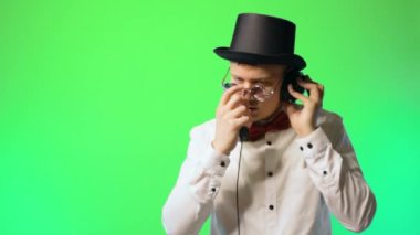 Şapkalı ve papyon gözlüklü genç sanatçı DJ mutlu sanatçı Chromakey müzik