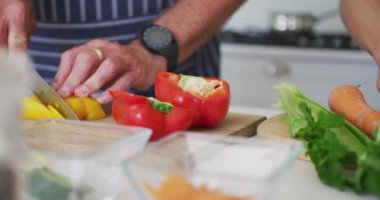 Mutfakta sebze doğrayan Kafkasyalı son sınıf öğrencisinin elleri. aktif ve sağlıklı emeklilik yaşam tarzı.