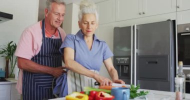 Mutfakta birlikte yemek pişiren önlük giyen Kafkasyalı yaşlı çiftin animasyonu. aktif ve sağlıklı emeklilik yaşam tarzı.