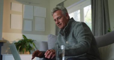 Kafkasyalı üst düzey bir adamın evrak işleriyle ve evde dizüstü bilgisayar kullanmasıyla ilgili animasyon. aktif ve sağlıklı emeklilik yaşam tarzı.