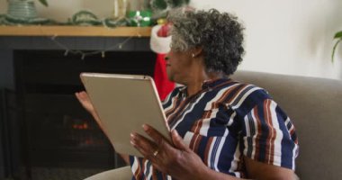 Mutlu Afro-Amerikan son sınıf öğrencisi bir kadının Noel 'de görüntülü konuşma yapması. Noel, şenlik ve evde gelenek.