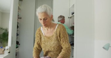 Kafkasyalı yaşlı çiftin seyahat için bavul hazırlama animasyonu. covid 19 salgını sırasında seyahat hazırlığı.