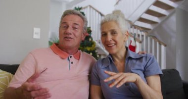 Kafkasyalı mutlu yaşlı çiftin Noel 'de görüntülü görüşme yaptığı animasyon. Noel, şenlik ve iletişim teknolojisi.