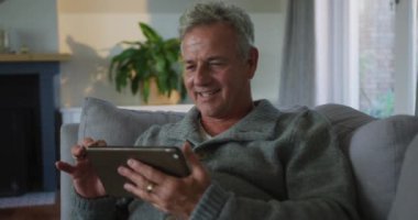 Evde akıllı telefon kullanan Kafkasyalı üst düzey bir adamın animasyonu. aktif ve sağlıklı emeklilik yaşam tarzı.