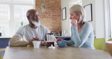 Evde kahve içerken birbirleriyle konuşan son sınıf melezleri. emekli çift yaşam tarzı konsepti