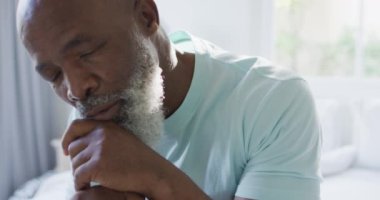 Yatak odasında baston tutan düşünceli Afrikalı Amerikalı adam. emeklilik yaşam tarzı, evde zaman geçirme..