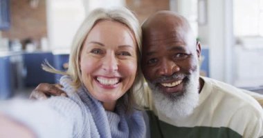 Oturma odasında kanepede oturup video görüşmesi yapan mutlu kıdemli çift. emeklilik yaşam tarzı, teknolojiyle evde..