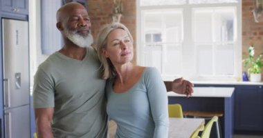 Karışık ırk son sınıf çifti evde birbirlerine sarılıyorlar. emekli çift yaşam tarzı konsepti