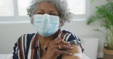 Afro-Amerikan son sınıf öğrencisinin aşılandıktan sonra yüz maskesi taktığı animasyon. covid 19 salgını sırasında üst düzey sağlık ve yaşam tarzı.